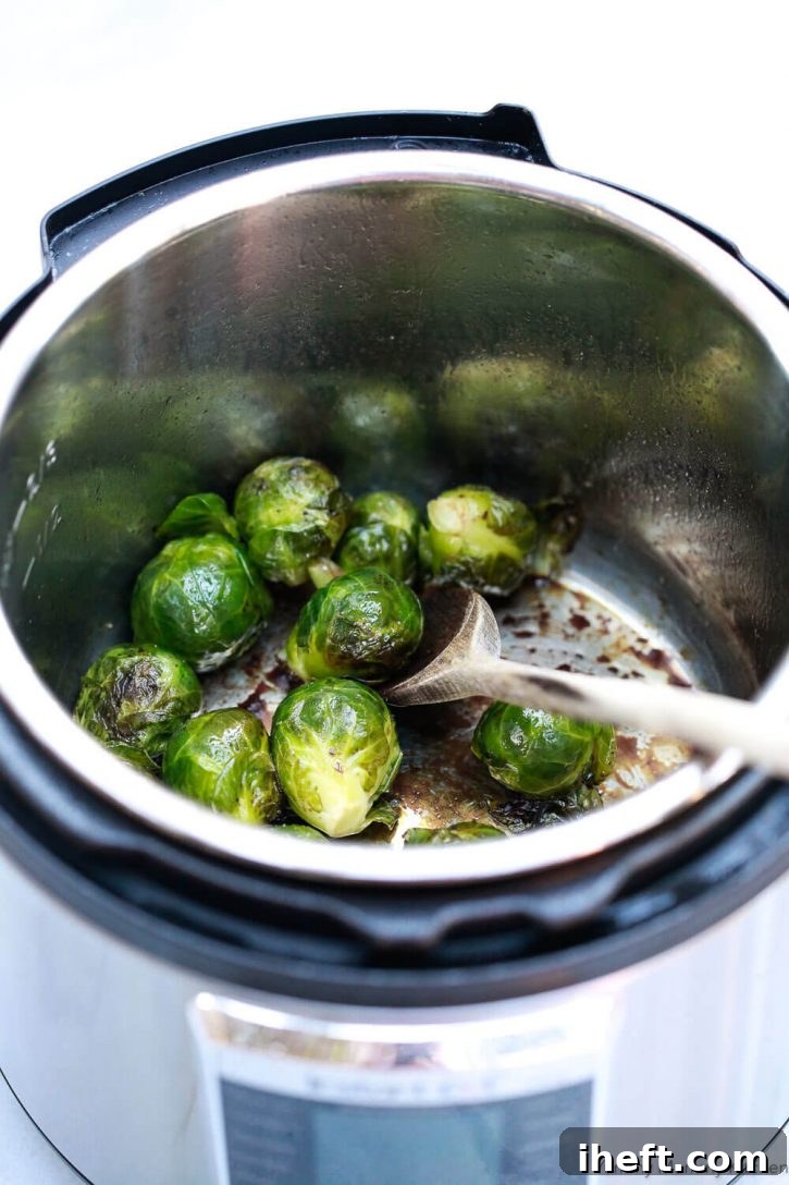 Whole balsamic-glazed Brussels Sprouts inside an Instant Pot pressure cooker, ready for the next step of crisping. This image demonstrates how to cook Brussels sprouts efficiently in an Instant Pot.