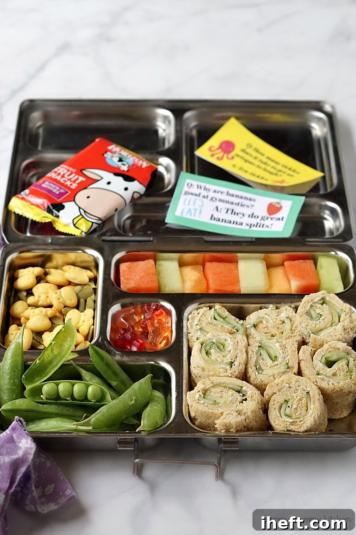 Planetbox lunch box with cucumber cream cheese sandwiches, Horizon Organic snacks, and printable jokes for kids, demonstrating a balanced and fun packed lunch.