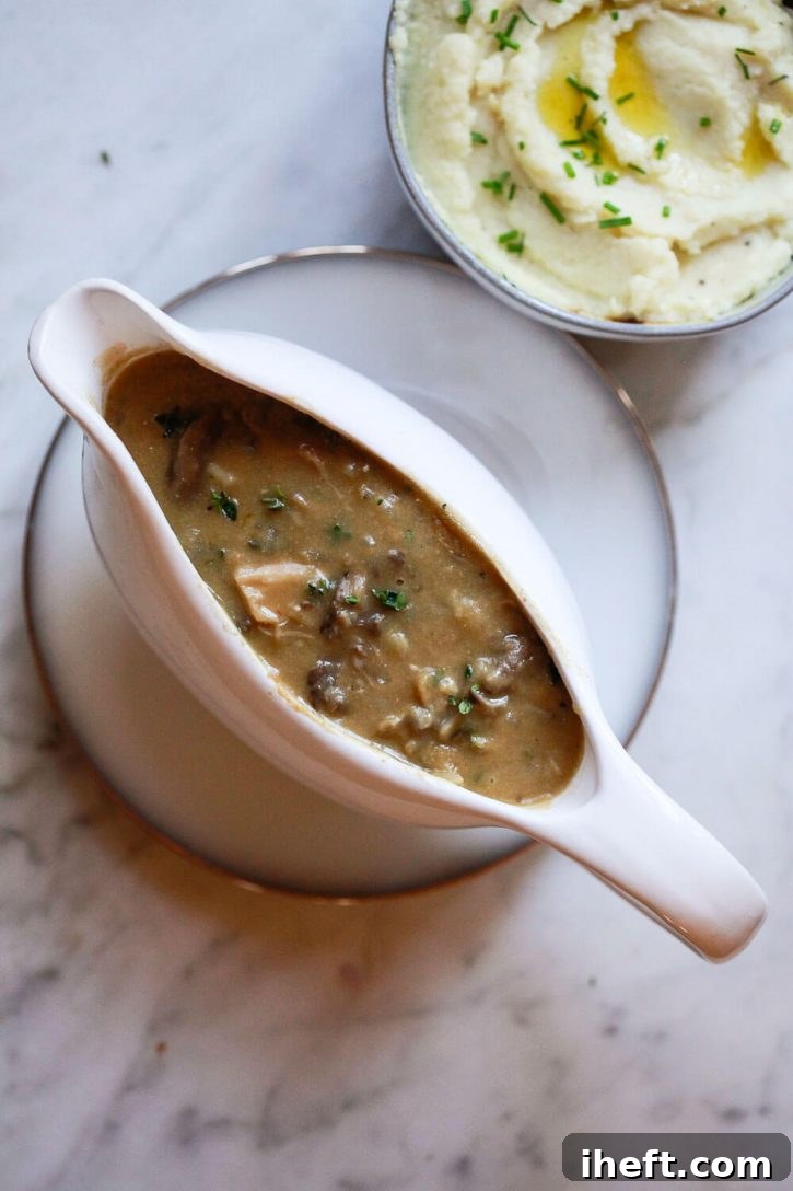 A pristine white gravy boat overflowing with homemade, rich brown vegan mushroom gravy, ready to be served.