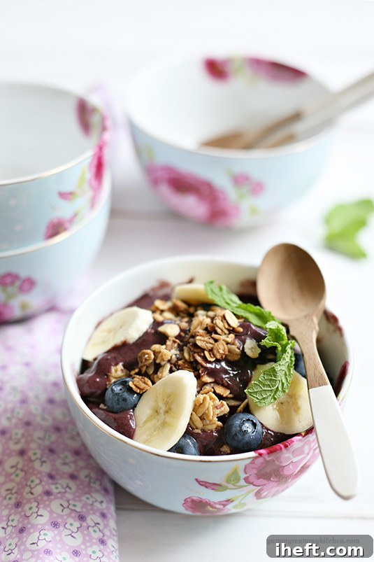 Beautiful acai breakfast bowl topped with berries, granola, and bananas.