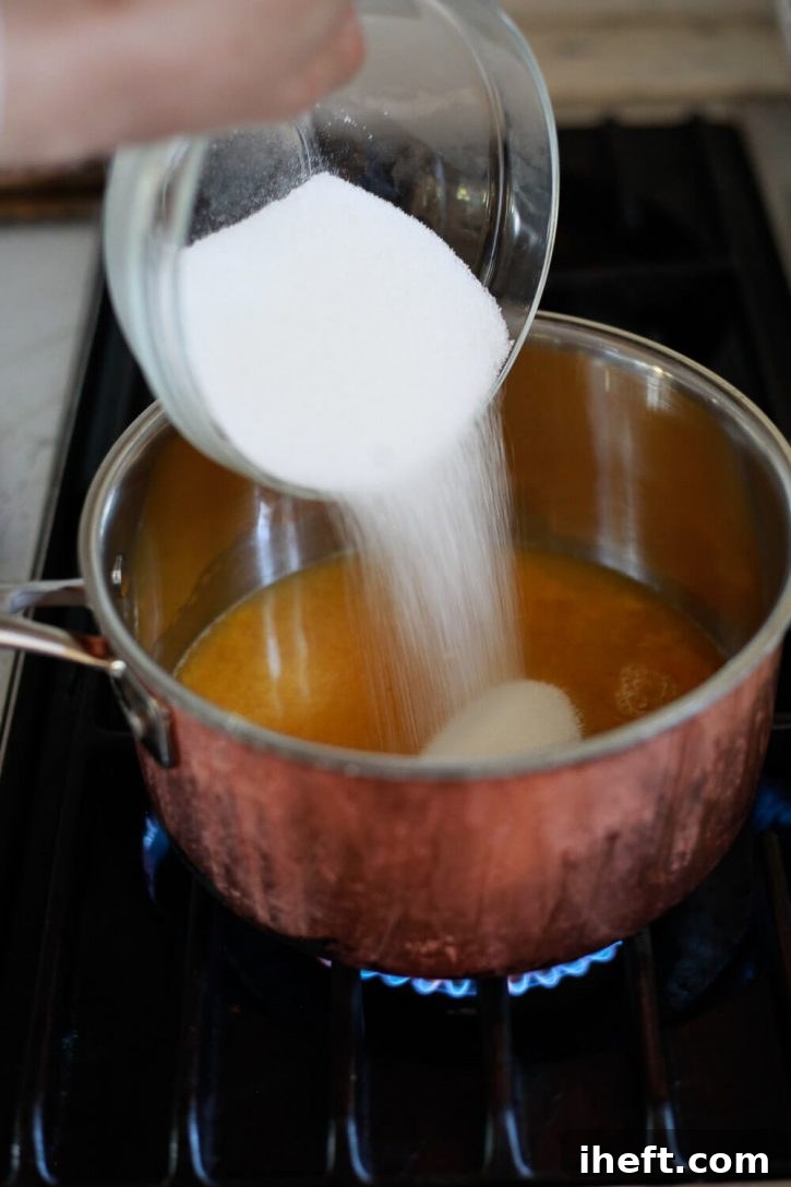 A close-up shot of Monk fruit sweetener being poured into a saucepan already containing fresh orange juice, a crucial step in preparing a healthy, sugar-free cranberry sauce. The kitchen is bright and inviting.