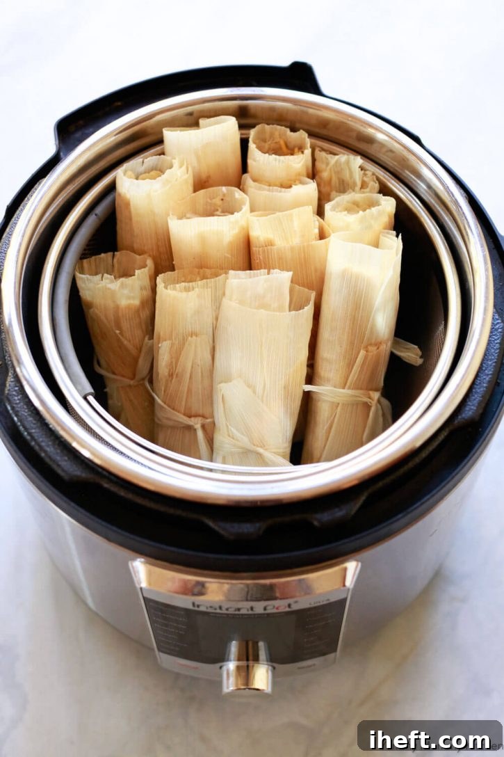 Tamales sit in the steamer basket of an Instant Pot pressure cooker ready to steam. 