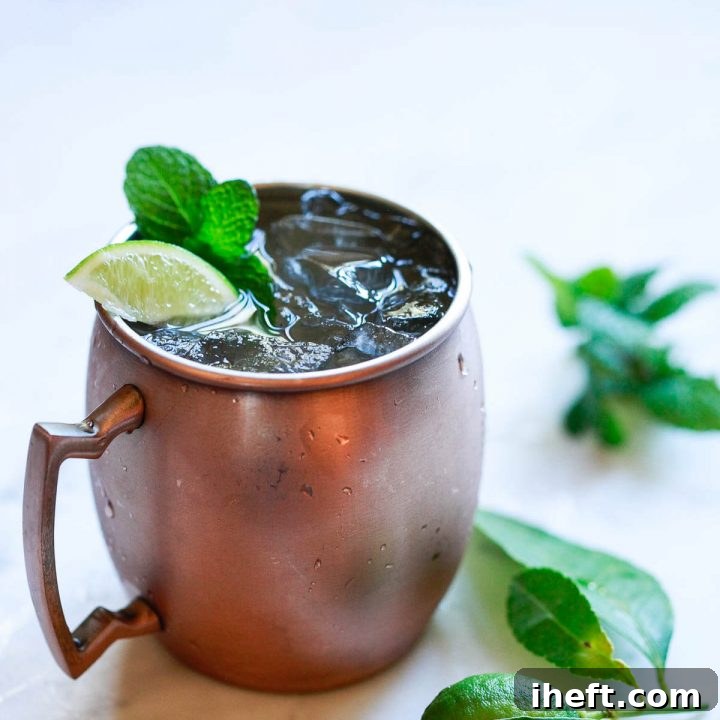 A beautifully presented Moscow Mule Mocktail with lime and mint garnish in a copper mug, ready to be served.