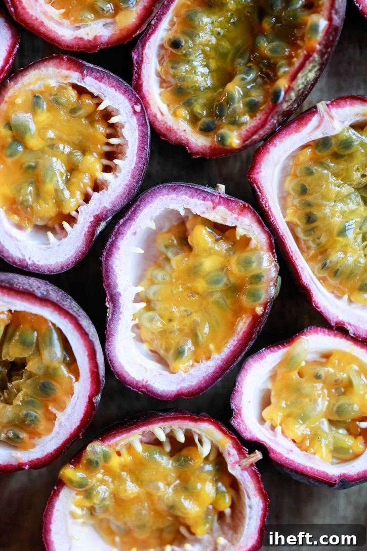 A close-up view of vibrant passion fruit halves, showcasing their juicy pulp and edible black seeds.