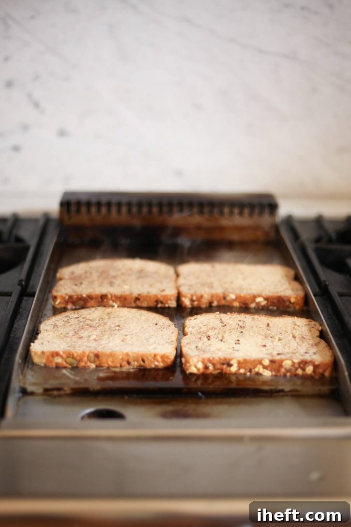 Slices of healthy vegan French toast cook on a griddle. 