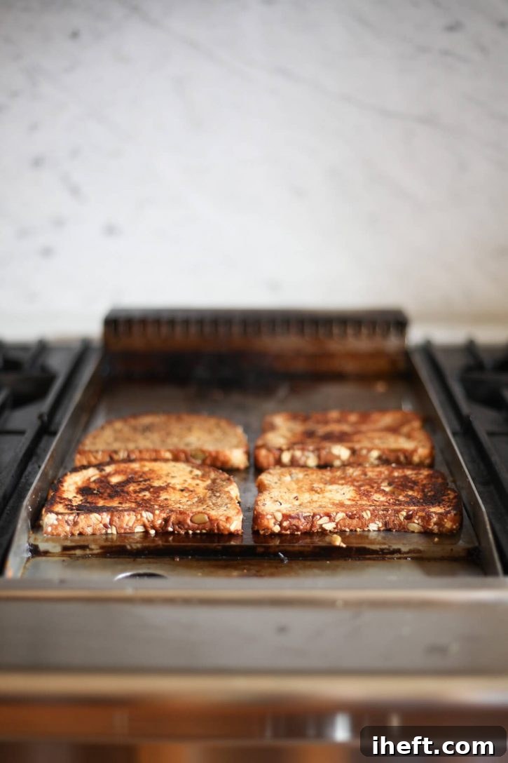 Vegan French toast browning on a griddle. 