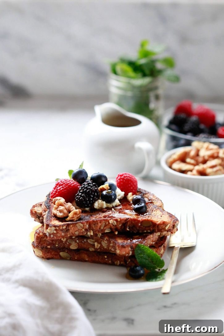 Plated healthy vegan french toast topped with berries and walnuts on a plate. 