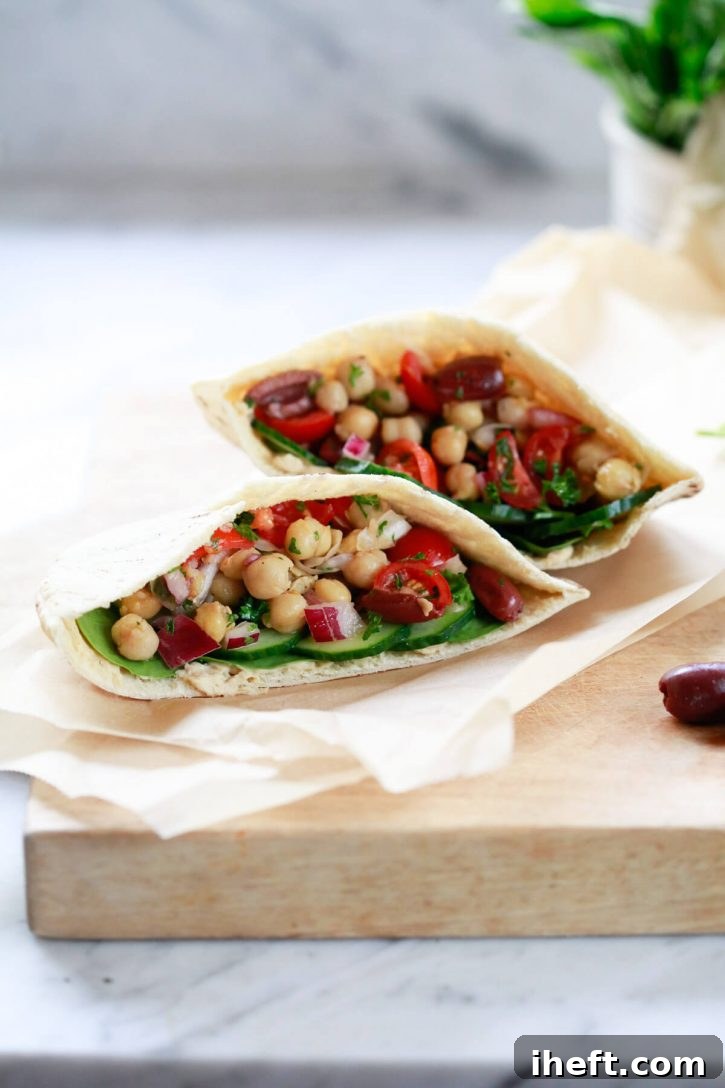 Two pita pockets filled with Balela, a Middle Eastern chickpea bean salad, and hummus and cucumbers. This image highlights the freshness and appeal of the Balela salad served in pita bread.