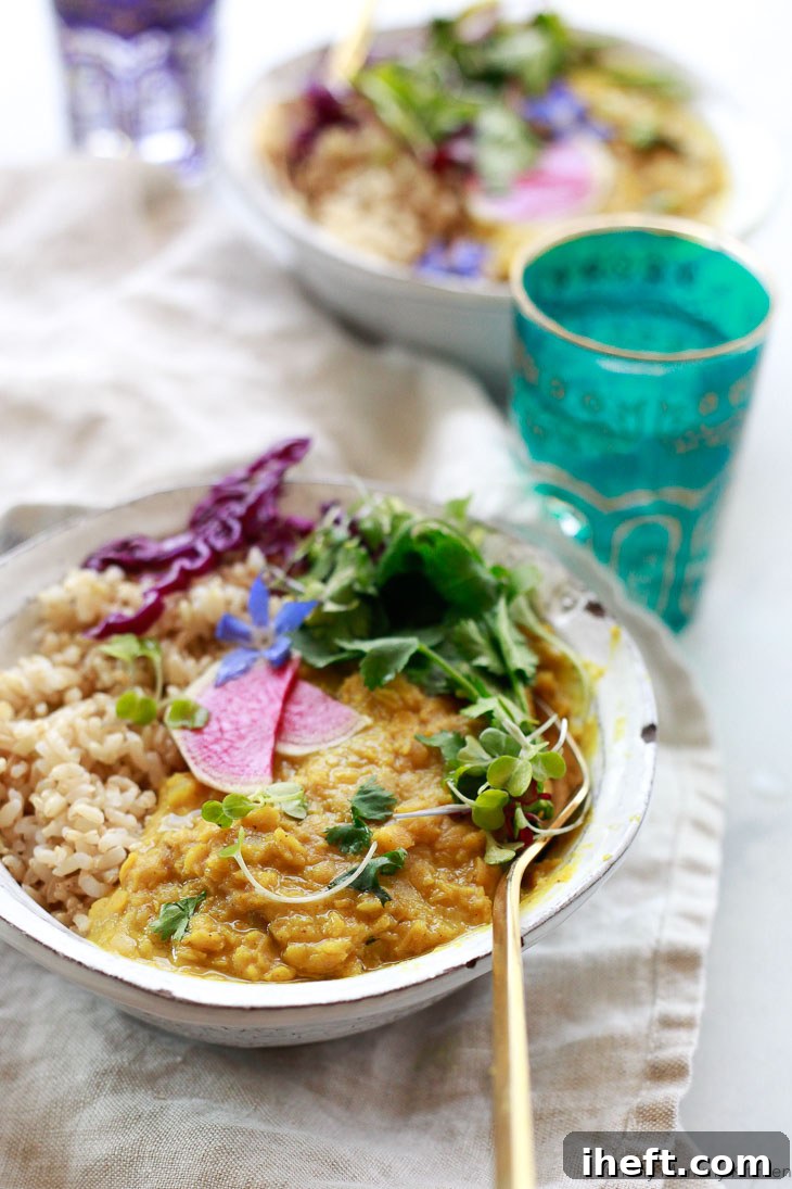 A bowl of simple red lentil dal, garnished with fresh herbs, ready to be served.