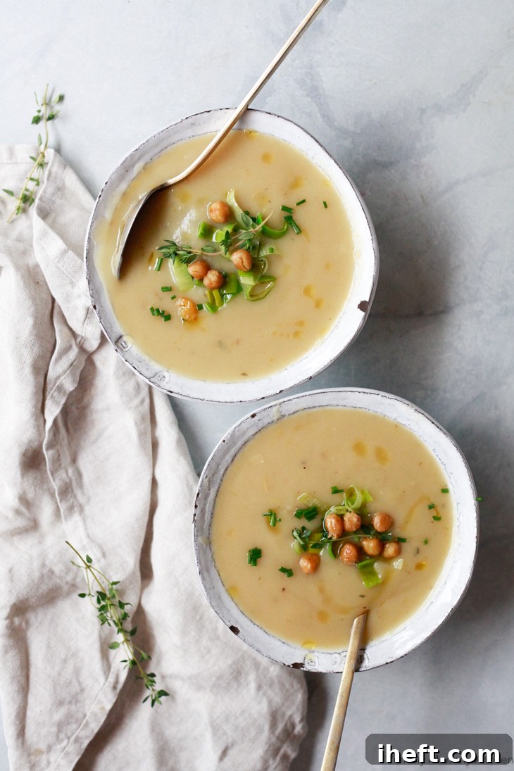 A creamy bowl of Instant Pot potato leek soup, garnished with fresh herbs.