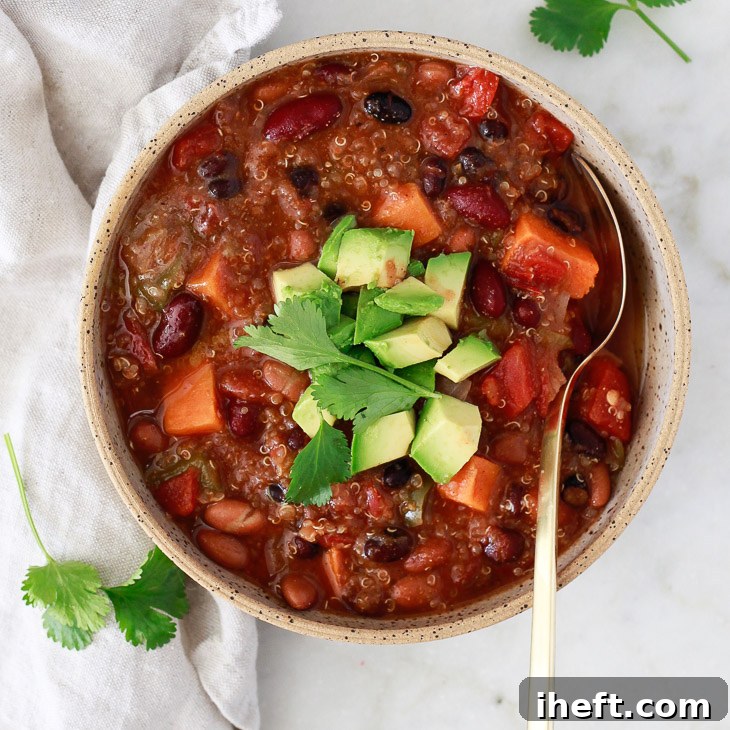 A rich and hearty bowl of Instant Pot vegetarian chili, topped with cilantro and avocado.