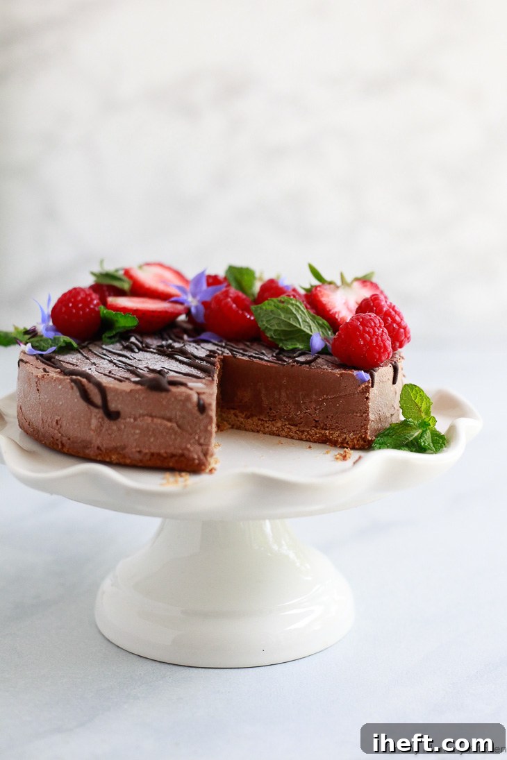 A decadent slice of vegan chocolate cheesecake, garnished with fresh berries.