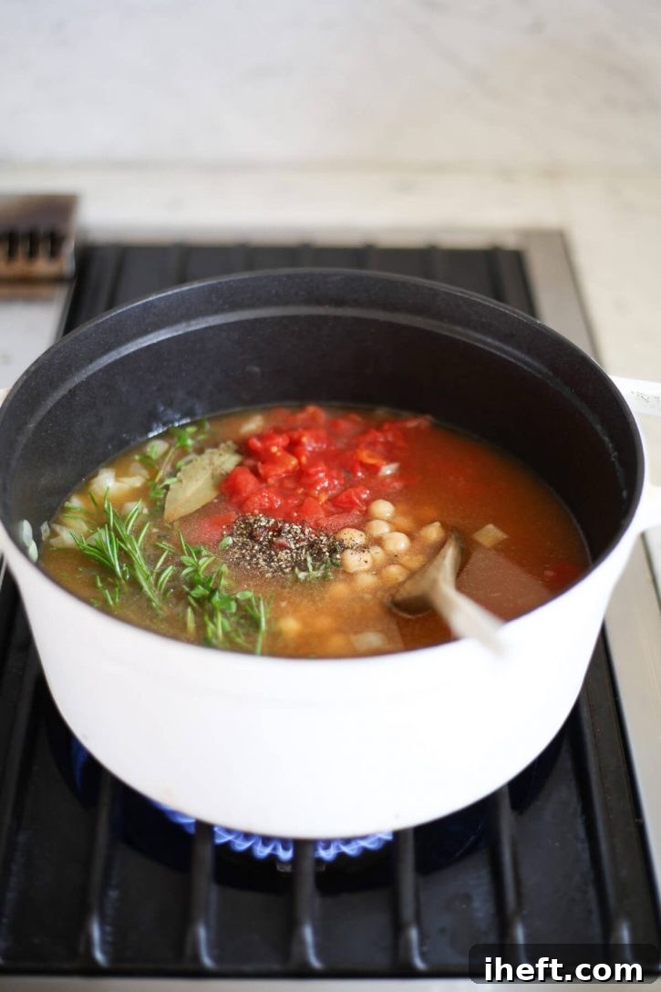 A pot of Italian chickpea soup in a pot on the stove. A delicious vegetarian Italian pasta e ceci soup. 