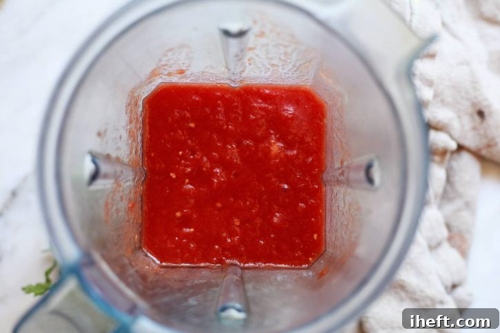 Whole canned tomatoes have been pureed in a blender to make an easy cooked salsa with canned tomatoes. 