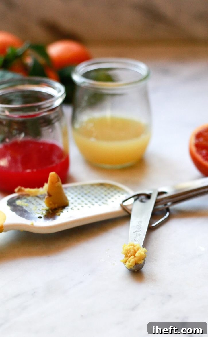 A close-up shot of fresh ginger being meticulously grated, its pungent fibers falling into a bowl, ready to be added to an apple cider vinegar drink. The focus emphasizes the raw, natural essence and preparation of the ingredient.