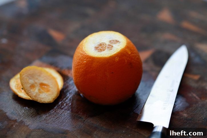 The top and bottom ends are precisely sliced off an orange, just exposing the juicy flesh, preparing it for the next step of peeling.