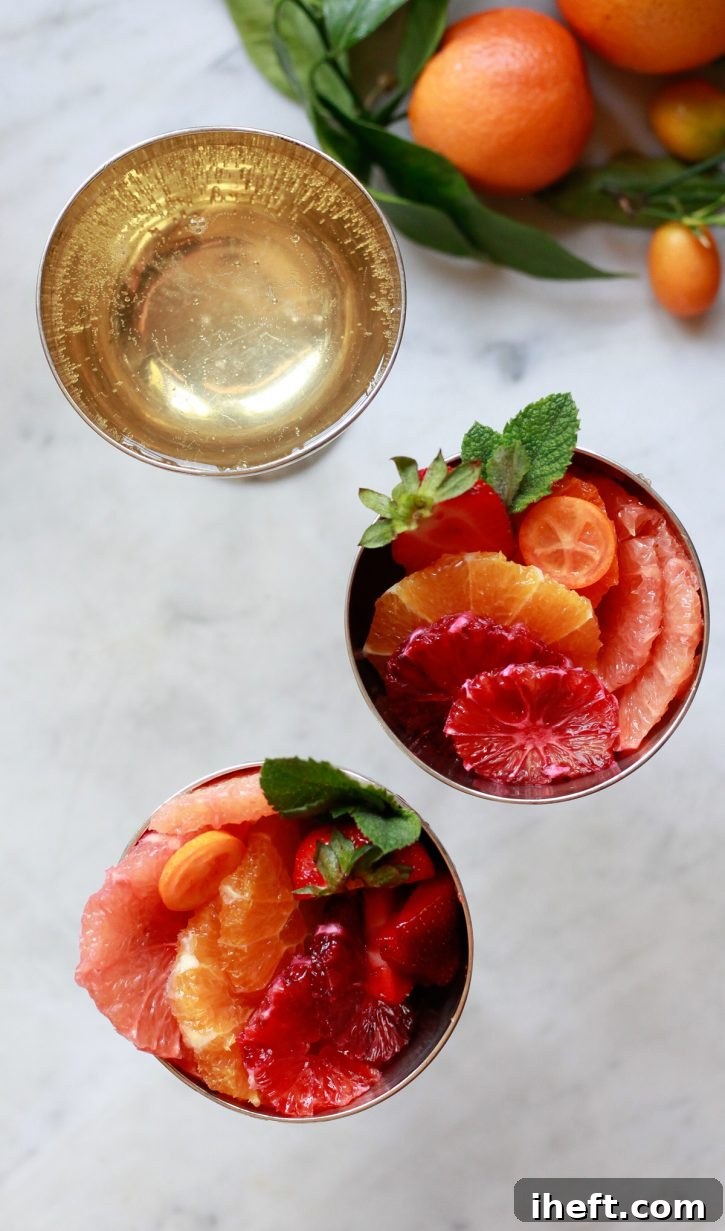 An inviting image of citrus fruit salad served in individual dishes, each accompanied by a flute of Champagne. This elegant presentation highlights the best winter or spring fruit salad recipe, perfect for a sophisticated brunch.