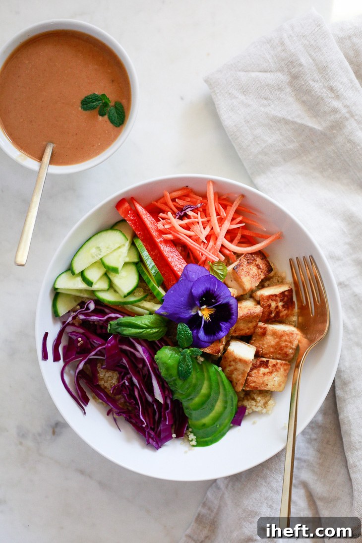 This Thai peanut sauce recipe is delicious with spring rolls or drizzled over Buddha bowls. This Buddha bowl is made with quinoa, tofu, avocado, purple cabbage, cucumber, and bell pepper. 