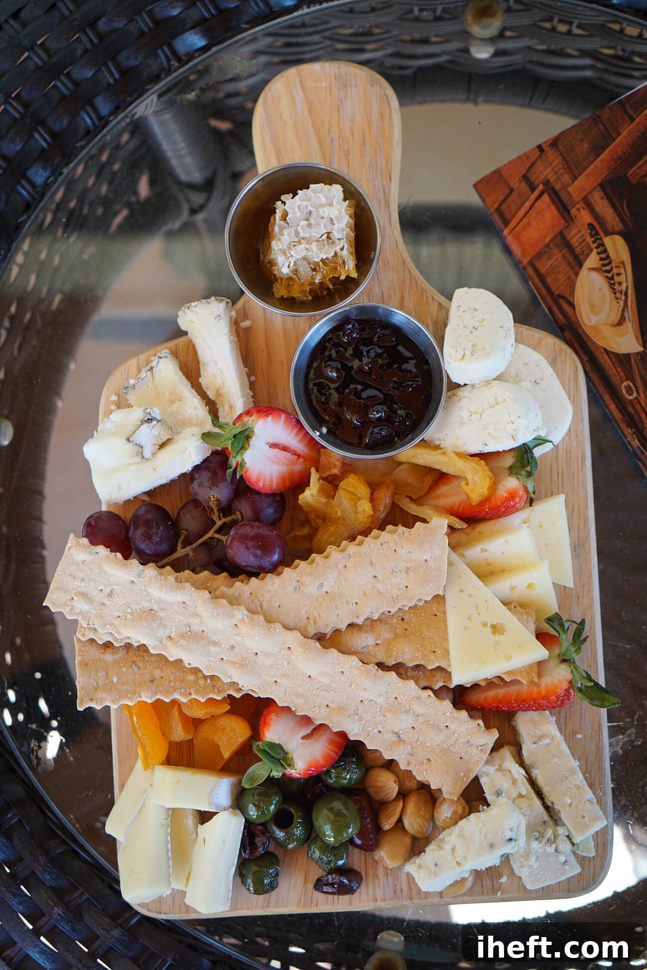 A delicious cheese board charcuterie at with cheeses, honeycomb, fruit and nuts. 