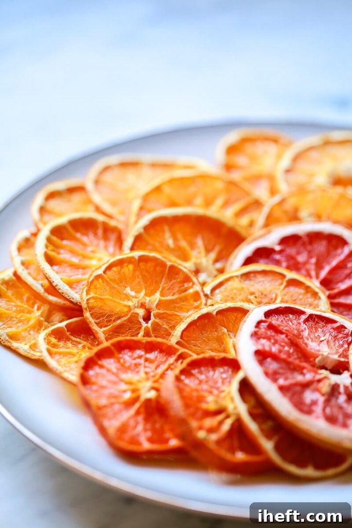 Beautiful dried orange slices on a white plate. Learn how to dry orange slices for garnishes, snacks, and Christmas ornaments and garlands.