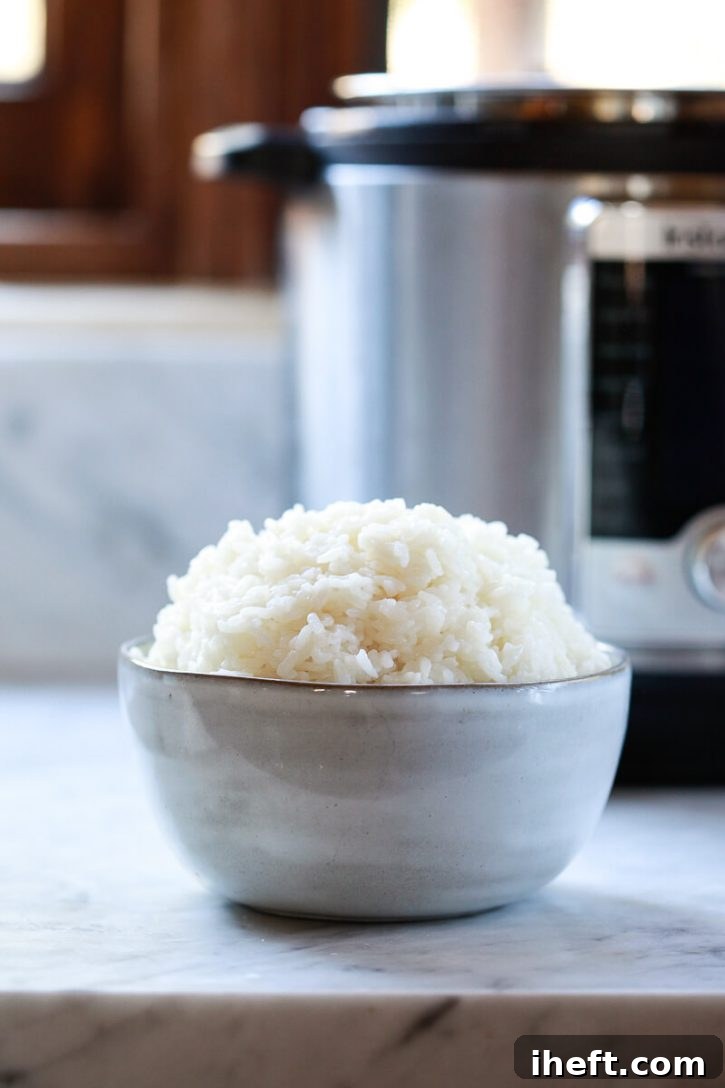 A bowl of perfect sushi rice sits on a kitchen counter in front of an Instant Pot pressure cooker. 