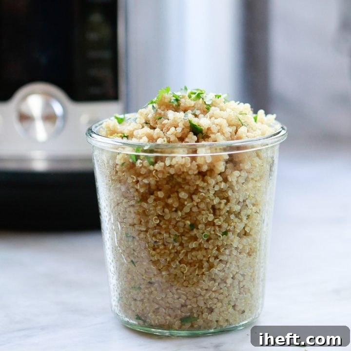 A glass jar filled with perfectly cooked quinoa, beautifully topped with fresh herbs, with an Instant Pot visible in the background.