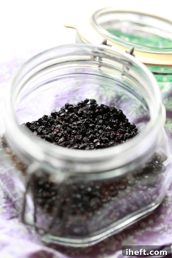 A jar of dried elderberries for making elderberry syrup or elderberry tea. 
