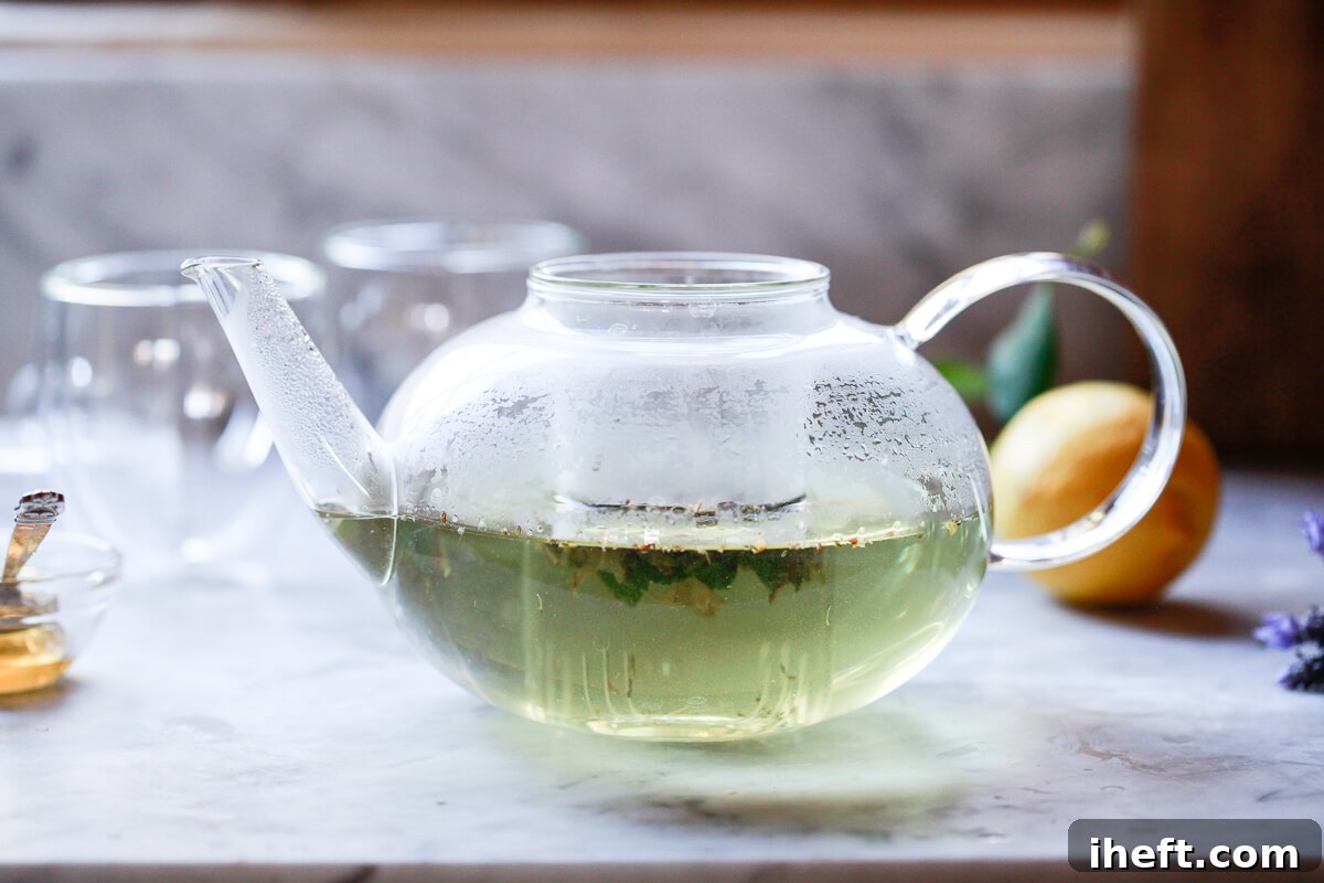 Lavender tea steeps in a glass teapot, showing the gentle infusion of flavor and color.