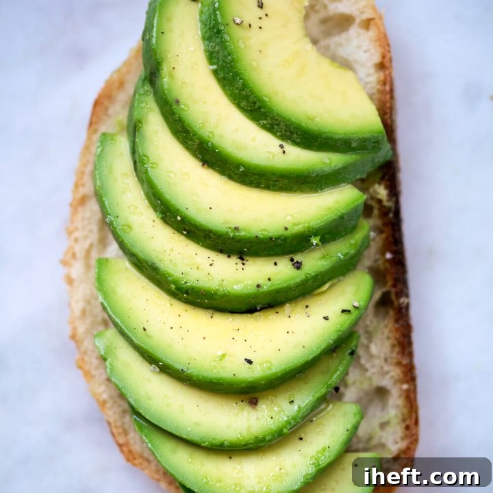 A perfectly sliced avocado on a piece of toast.
