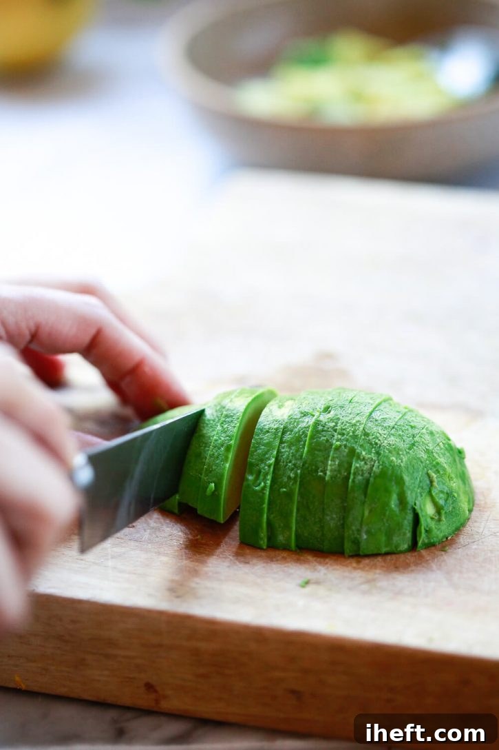 Half of a peeled avocado is cut into perfect slices. 