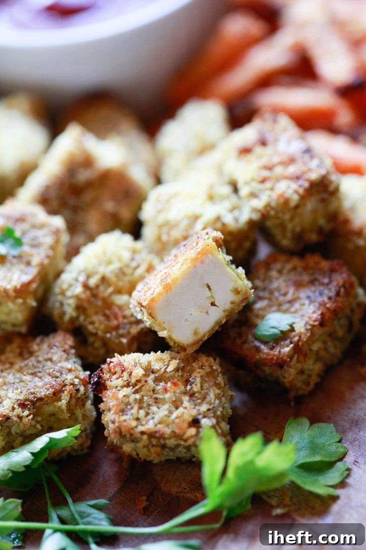 A close-up shot of perfectly golden and crispy baked tofu nuggets, showcasing their inviting texture and appearance, an excellent vegan meal idea for beginners.