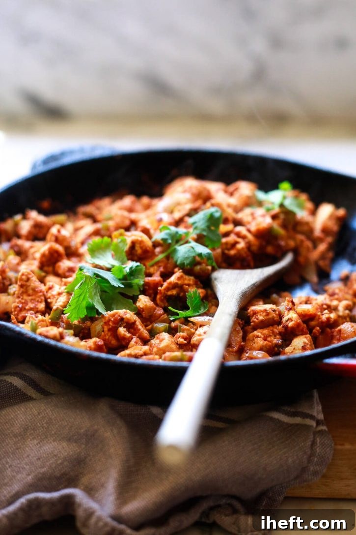 A skillet brimming with Chipotle sofritas, a crumbled Mexican tofu recipe that is smoky and spicy, perfect for tacos, burritos, or burrito bowls.