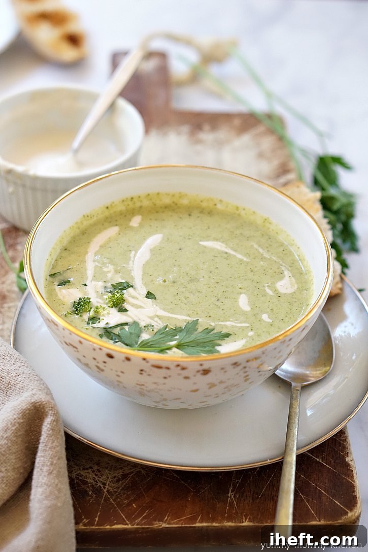 A delightful bowl of creamy broccoli soup, generously garnished with a swirl of homemade cashew cream and a sprinkle of fresh parsley, promising rich flavor.