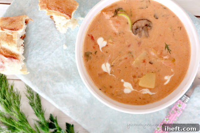 A close-up of Salmon Chowder in a bowl, garnished with a heart design made from cream.