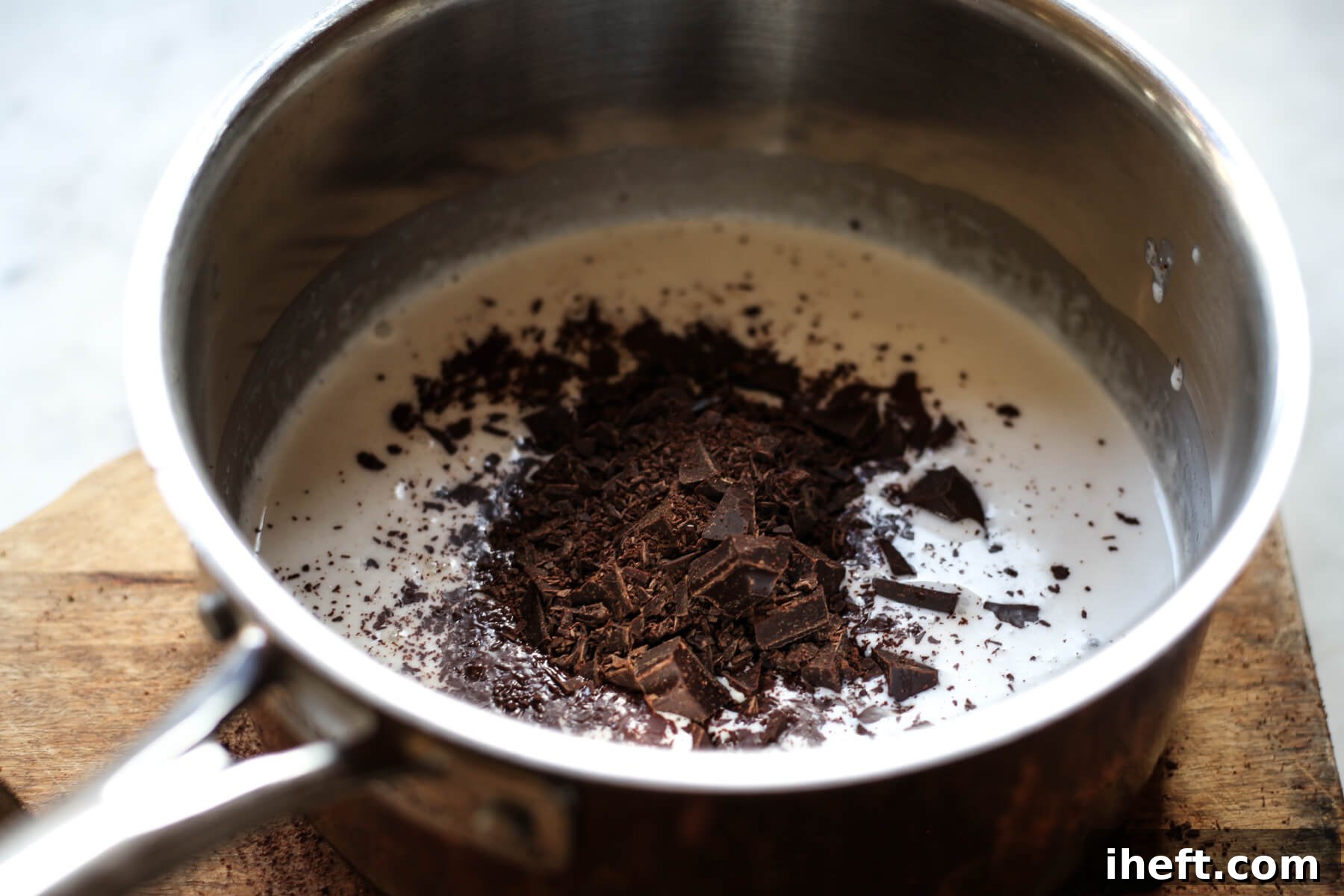 Chopped chocolate is added to hot coconut milk to make a vegan chocolate ganache frosting.