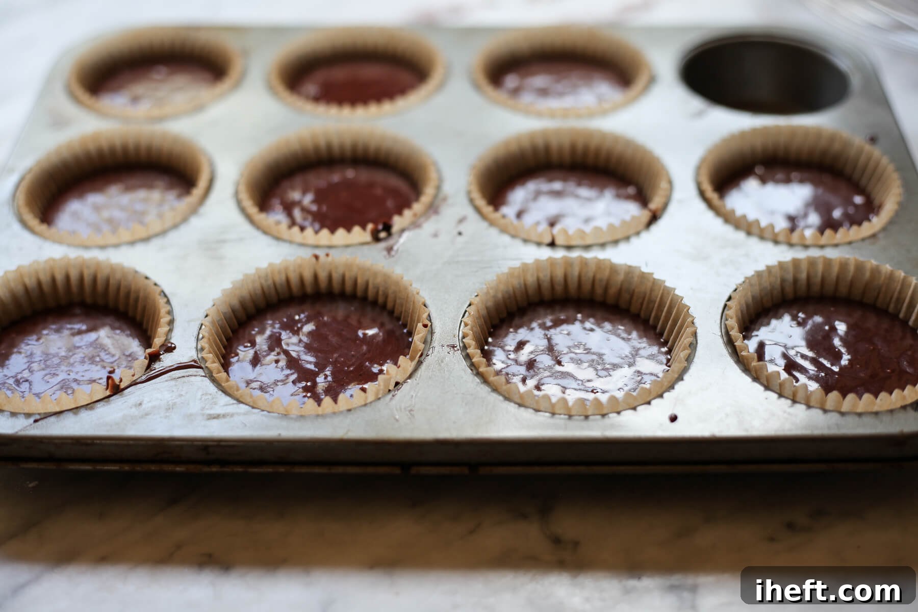 Vegan chocolate cupcake batter in a muffin tin.