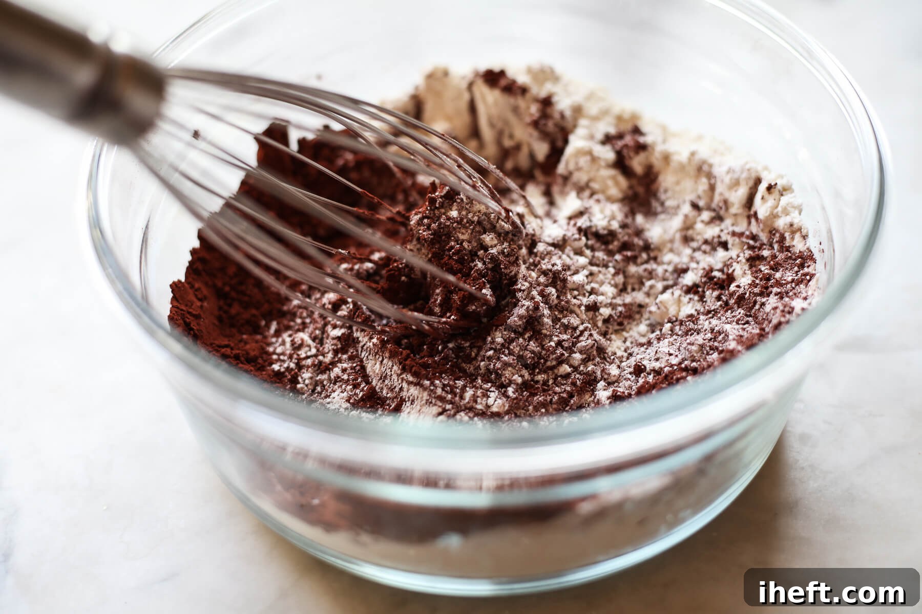 The dry ingredients for vegan chocolate cupcakes are whisked together.