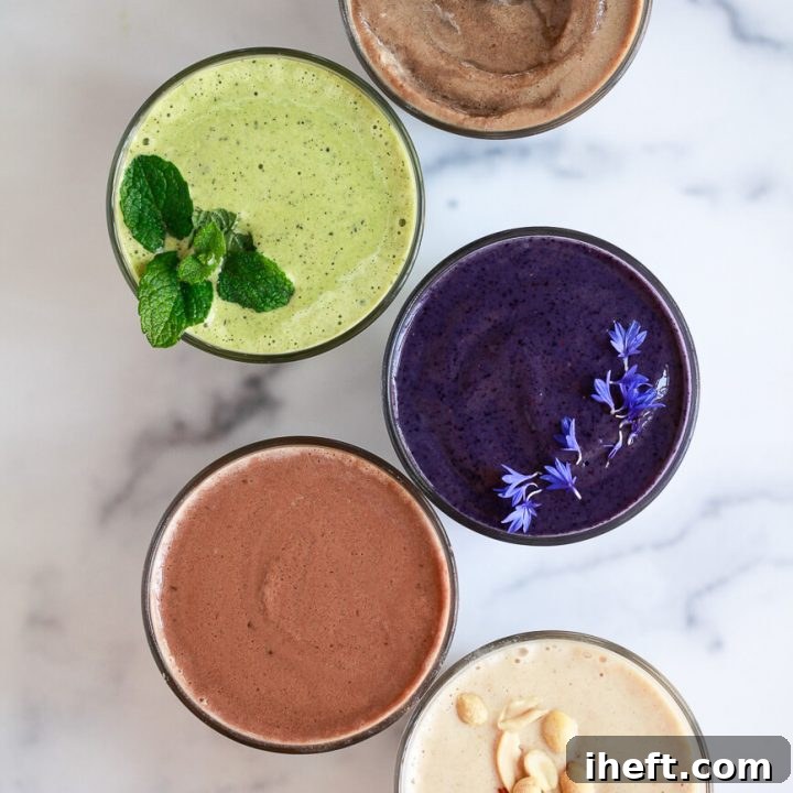 Five different protein shakes beautifully arranged on a marble countertop, showcasing their vibrant colors and appealing textures.