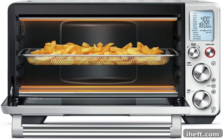 A photo of a Breville smart oven with french fries cooking inside an air fryer basket.