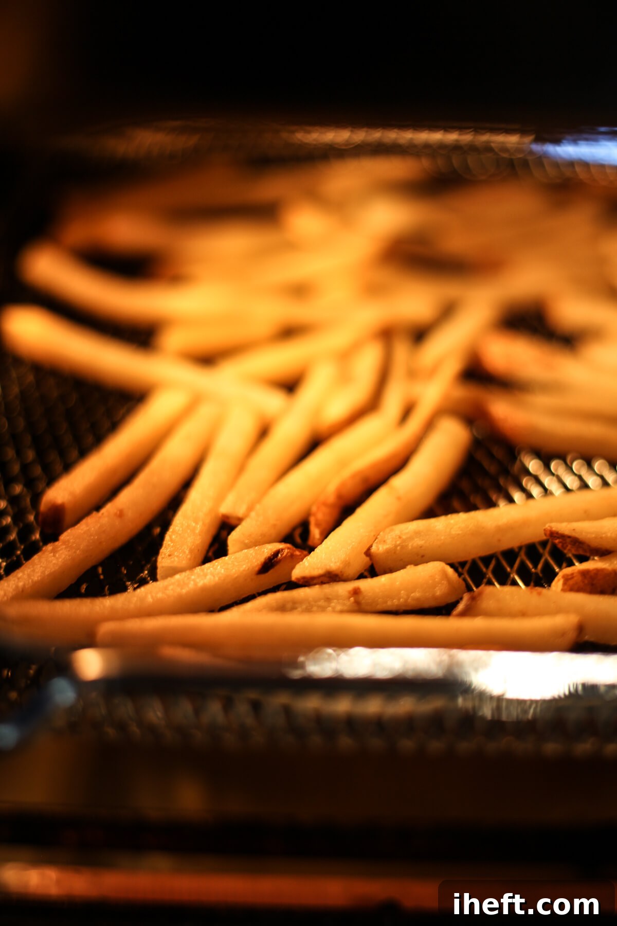 Frozen French fries cook in an air fryer.