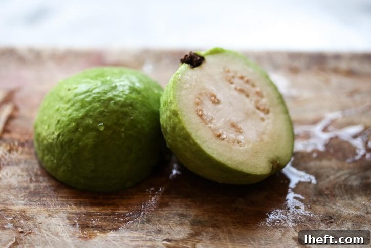 A Thai white guava cut in half on a cutting board. 