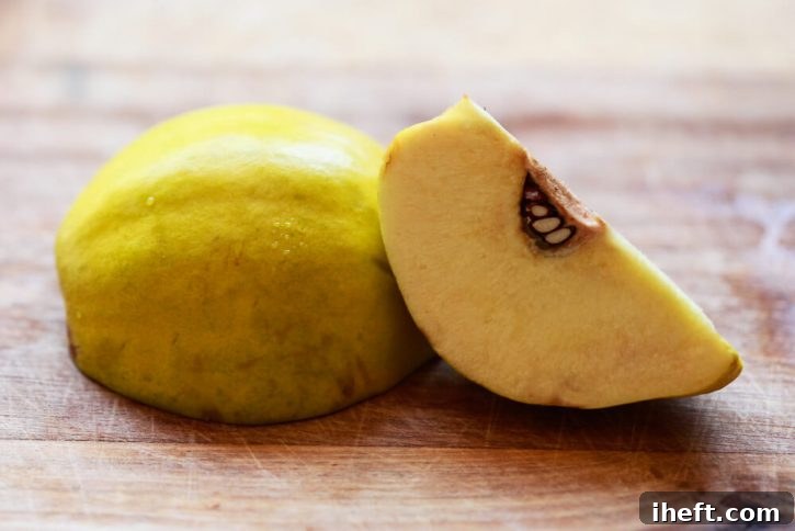 Half of a quince fruit cut in half on a cutting board. 