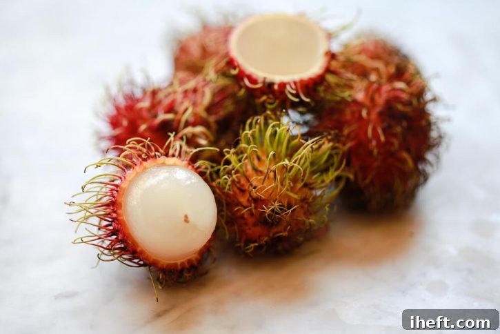 A pile of rambutan sits on a marble countertop. This exotic fruit is harry on the outside and juicy on the inside. 