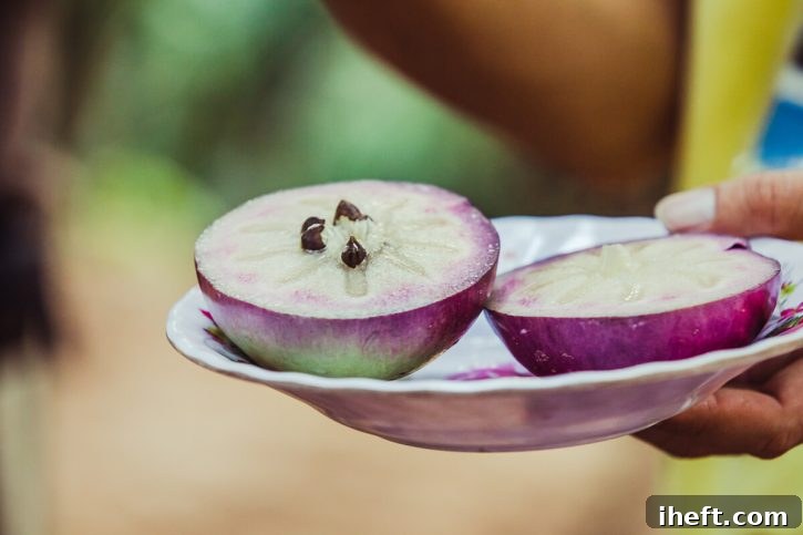 Purple star apple halves are held on a dish. 