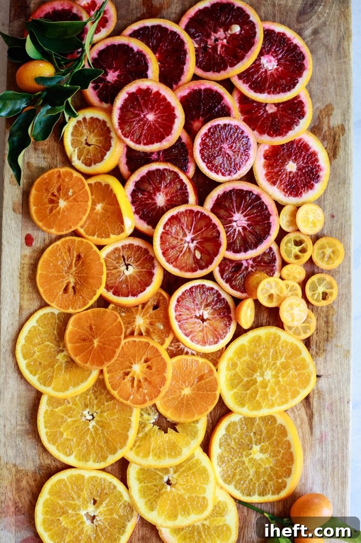 A beautiful photo of slices of orange, tangerine, blood orange, and kumquat on a cutting board. 