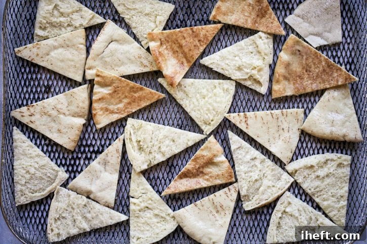 Pita chips in an air fryer basket.