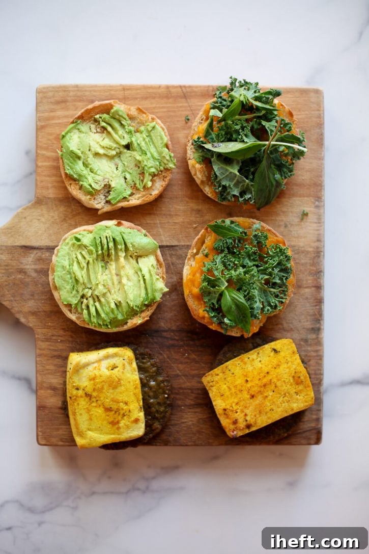 Vegan breakfast sandwiches are assembled on a cutting board. 