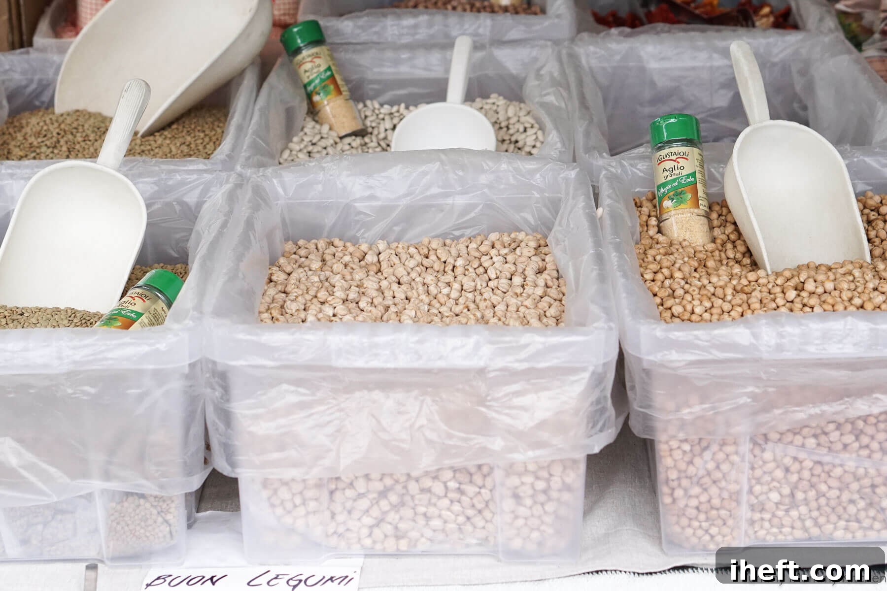 Bins filled with dried legumes at a farmers market in Italy. A sign reads, "buon legumi"