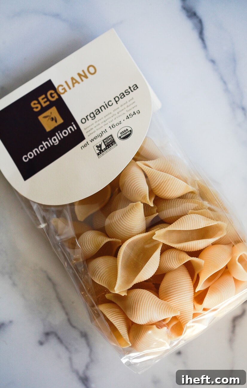 A bag of Seggiano conchiglioni organic pasta jumbo shells sits on a white marble countertop. 