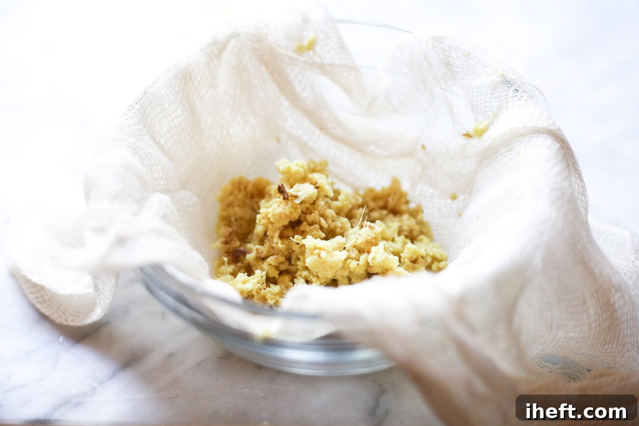 A small bowl lined with cheesecloth is prepared to receive grated ginger, illustrating setup for manual ginger juice extraction.
